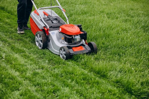 man-cutting-grass-with-lawn-mover-back-yard_1303-22794